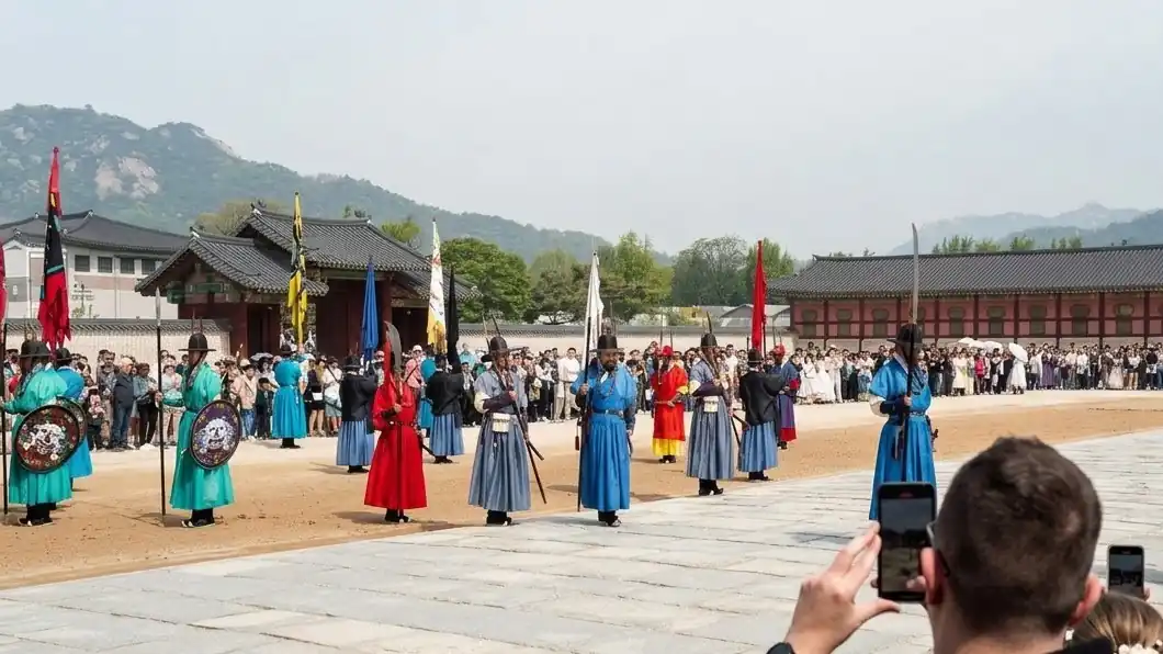 Visitors filming the royal guard ceremony at Gyeongbokgung Palace on their phones