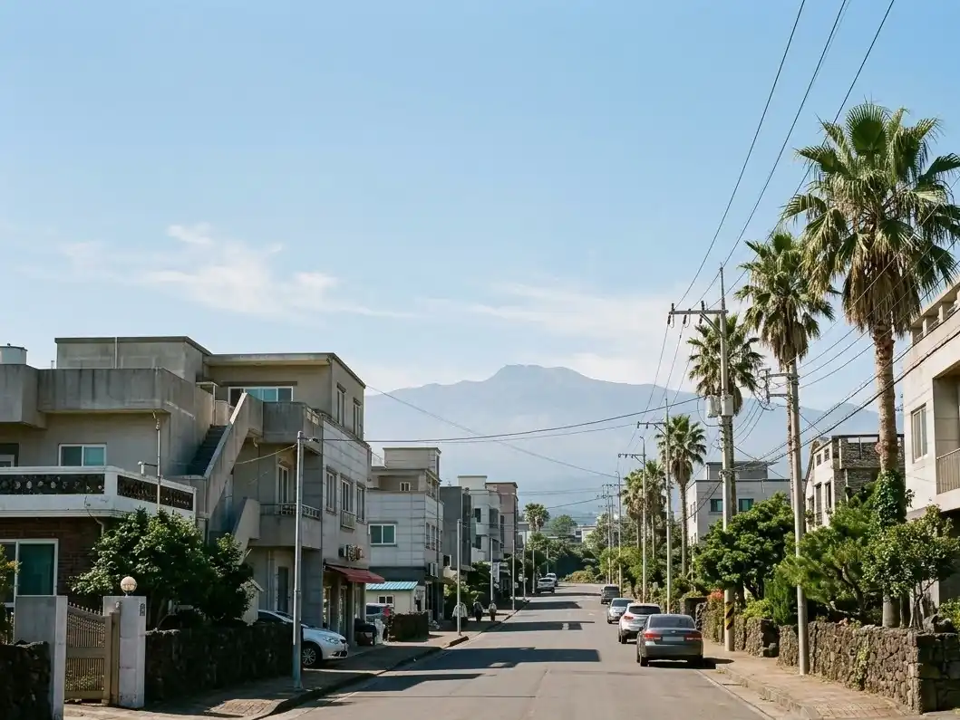 A Jeju City street with low buildings and Hallasan in the distance