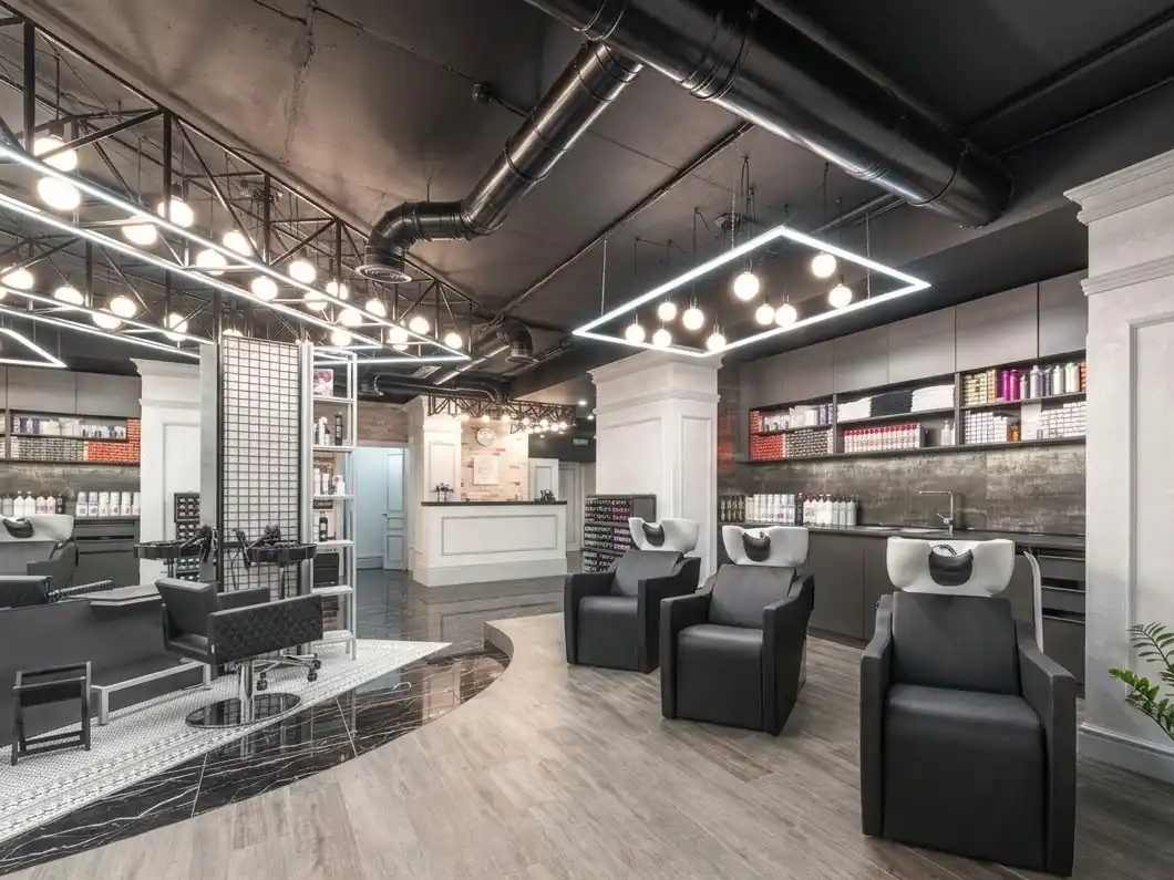A modern hair salon with black styling chairs and mirrors